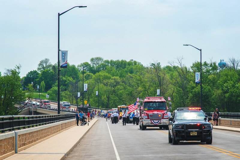 a group of people walking across a bridge
